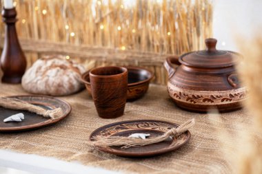 El yapımı çömlek, köy ekmeği ve kış tatili için doğal süslemeler içeren güzel bir masa..