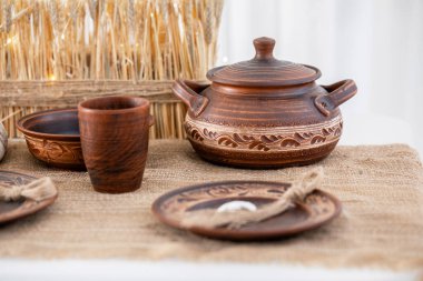 Çok güzel düzenlenmiş bir masa, sade çömlek ve sofra takımı içeriyor, şenlikli bir toplantı için hazır. Sahne, kışın sıcaklığını ve Noel ruhunu doğal dokularla yakalıyor..