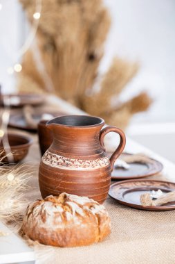 Sıcacık bir kış ayarı sergileri güzel yapılmış çömlekçilik ve taze pişmiş ekmek. Sıcak tonlar Noel ve yeni yıl kutlamaları için mükemmel bir şenlik ortamı yaratıyor..