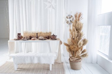 Sıcak bir kış dekoru, fırında pişmiş yiyecekler, kırsal çömlekçilik ve büyüleyici bir kurutulmuş çiçek ağacıyla güzel düzenlenmiş bir masaya sahiptir. Noel ve Yeni Yıl gibi kutlamalar için ideal..