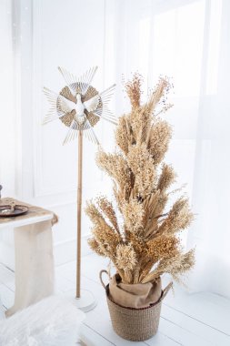 Sıcak bir kış düzeninde dekoratif bir yıldızın yanındaki sepette kurumuş bir çiçek sergisi sergilenir. Bayram mevsimi için sıcaklığa ve tatil ruhuna vurgu yapıyorum..