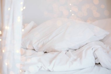 Kabarık beyaz yastıklar ve battaniyelerle süslenmiş bir karşılama odası. Yumuşak, sıcak ışıklar Noel 'i kutlamak ve yeni yılı karşılamak için mükemmel bir ortam yaratır..