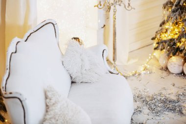 A plush white sofa is positioned against a backdrop of warm, twinkling lights. clipart