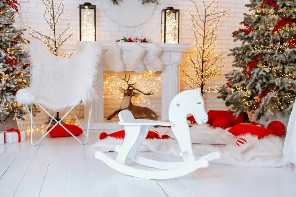 Sıcak bir Noel ortamında güzel dekore edilmiş bir ağaç, güzel bir sallanan at ve şenlikli hediyeler vardır. Odanın etrafında hafif ışıklar parlıyor, tatiller için büyülü bir atmosfer yaratıyor..