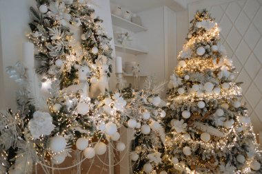 Beyaz süsler ve narin ışıklarla süslenmiş iki güzel Noel ağacı şenlikli bir atmosfer yaratıyor. Bu kış ayarı tatil sezonunun neşesini yakalıyor. Kutlama için mükemmel..