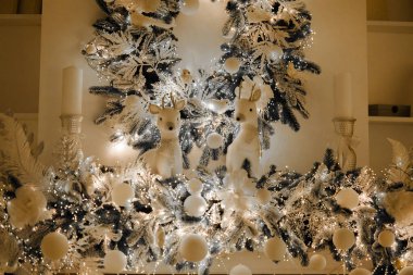 Güzel süslenmiş bir kış sergisi hediye kutularıyla çevrili bir Noel ağacı. Yumuşak beyaz ışıklar süslemeleri aydınlatıyor, tatiller için sıcak ve şenlikli bir atmosfer yaratıyor..