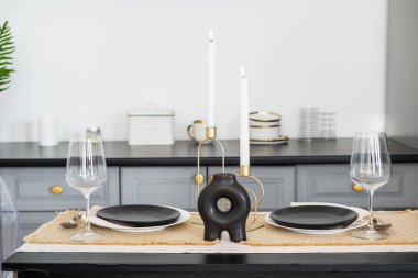 Siyah tabaklar ve zarif camdan yapılmış güzel bir yemek masası..