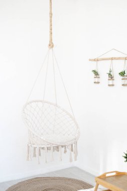 Rahat bir sallanan sandalye, parlak, dağınık iç mekanı tamamlar..