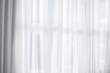 Güneş ışığı, parlak bir odayı bembeyaz perdelerden nazikçe aydınlatır..