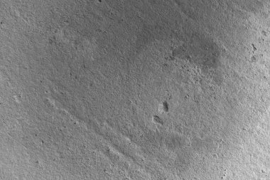 Çeşitli geometrik desenleri ve işaretleri gösteren desenli gri yüzeyin yakın görüntüsü.