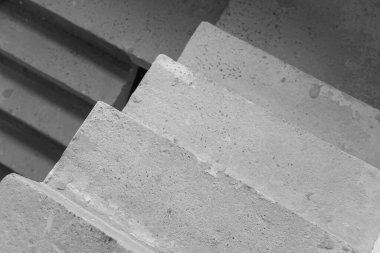 Çağdaş bir yapıda yükselen desenli beton merdivenlerin yakın görüntüsü.