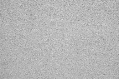 Gün ışığıyla aydınlatılan ince desenli pürüzsüz gri bir duvar..