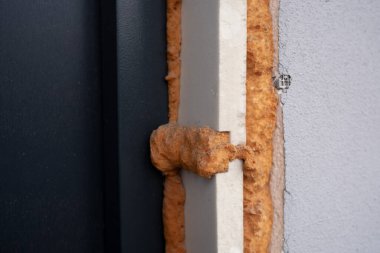 Close-up view of foam insulation applied around a window frame outdoors. clipart