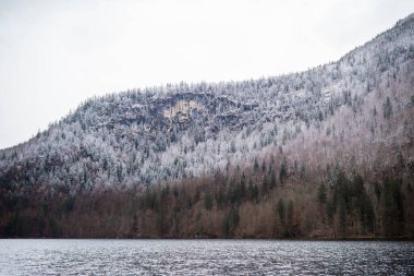 Sakin göl mevsimsel güzelliği yansıtırken kar dağı kaplıyor..