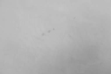 Kalıplı gri bir yüzey parlak ışığın altında belli belirsiz çizikler ve işaretler gösterir..