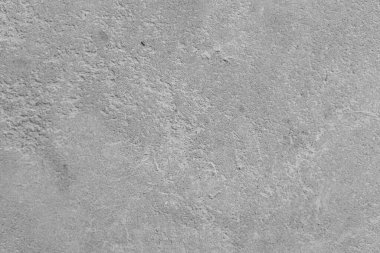 İnce desenleri ve ışık yansımaları olan desenli gri bir yüzeyin yakın görüntüsü.