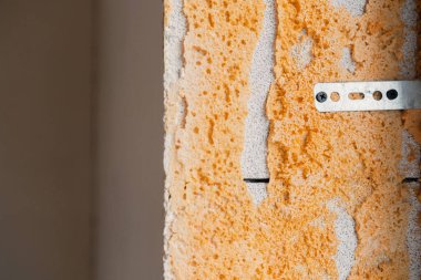 Malzemelerle yapılan onarım çalışmalarını gösteren dokulu duvar görüntüsü.