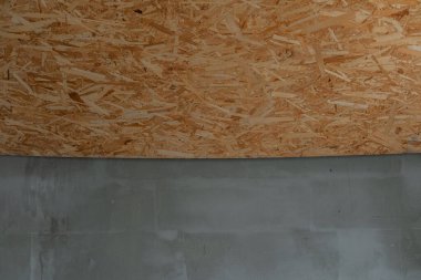 Beton bir duvarın üzerine ahşap bir tahta panel monte edilmiştir..