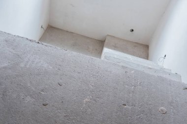 Beton merdiven parlak ve modern bir iç ortamda yükselir..