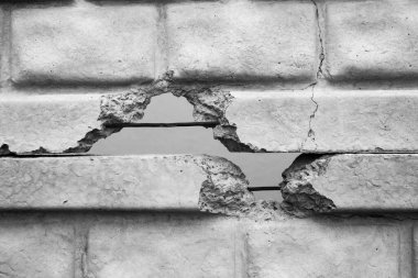 A concrete wall displays significant cracks, exposing underlying steel bars and textures. clipart