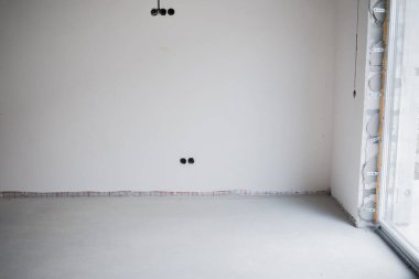 Tarafsız duvarları ve pürüzsüz döşemeleri olan boş oda dekorasyona hazır..