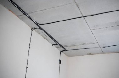 Bir inşaat alanının tavanı boyunca elektrik kabloları görülebilir..