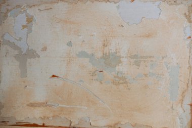 Desenli bir duvar, soyulmuş boya ve solmuş renklerle aşınma izleri gösterir..