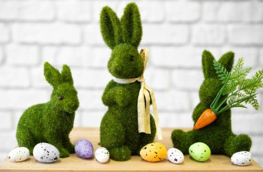 Fluffy green bunnies stand beside pastel-colored eggs ready for Easter festivities. clipart