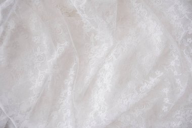 Yumuşak beyaz dantel yayılmış, tasarım projeleri için mükemmel desenler sergiliyor..