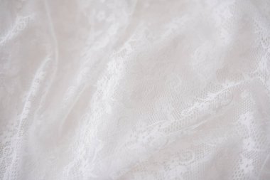 Yumuşak beyaz dantel kumaş nazikçe dinleniyor, karmaşık desenler ve dokular sergiliyor..