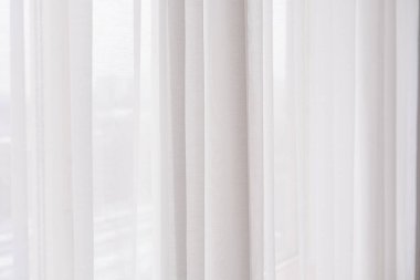 Saf beyaz perdeler zarifçe asılarak, doğal ışığın içinden süzülmesine izin verir..