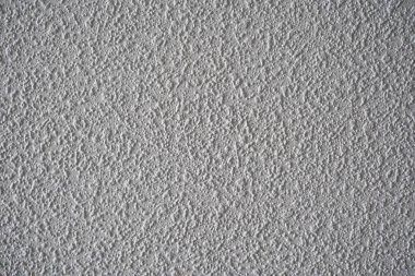 Karmaşık desenlerini ve tasarımlarını vurgulayan desenli gri bir duvarın yakın plan görüntüsü.