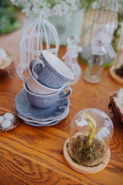 Seramik bardaklar, yosun ve çiçek aranjmanlarının yanında..