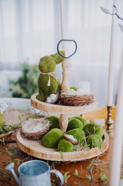 Yosun dekoru, tavşanlar ve ahşap tepside yuvaların yer aldığı bahar temalı bir düzenleme..