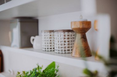 Modern bir mekanda şık raf dekoratif kaplar ve yeşillik sergileniyor..