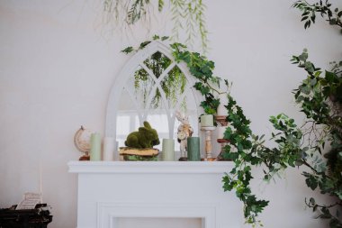 Canlı bir manto, büyüleyici bir odada yeşillik, mumlar ve yumuşak bir tavşan sergiler..