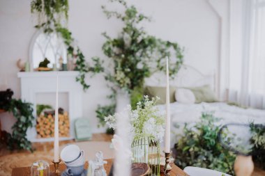 Bitkilerle, mumlarla ve yumuşak mobilyalarla süslenmiş sakin bir oda sükuneti davet eder..