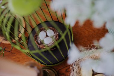 Tahta bir masanın üzerinde birkaç yumurta bulunan güzel bir yuva.