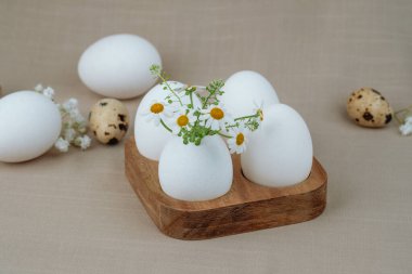 Tahta tepside papatya çiçekli beyaz yumurtalar. Paskalya sırt çantası. çiftlik kavramı. 