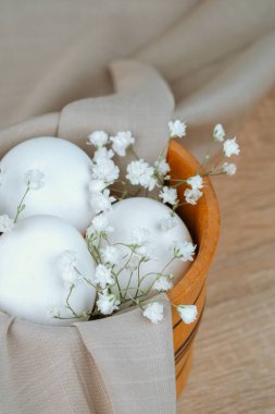 Tahta kasede bebek çelenkli beyaz yumurtalar. Paskalya kuşağı.