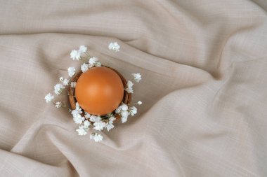 Çiçek yuvasında kahverengi yumurta. Paskalya yumurtası. Paskalya kuşağı. 