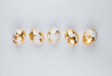 Beyaz arka planda altın beyazı yumurtalar, üst manzara. Paskalya bayrağı. 