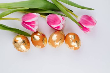 Beyaz arka planda altın sarısı yumurtalar, üst manzara. Paskalya bayrağı. 