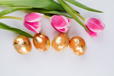 Beyaz arka planda altın sarısı yumurtalar, üst manzara. Paskalya bayrağı. 