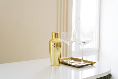  Beyaz Tezgahta Şık Şarap Kadehiyle Altın Kokteyl Sallayıcısı