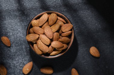 Arka planda koyu dokulu badem kasesi sağlıklı atıştırmalık kavramı