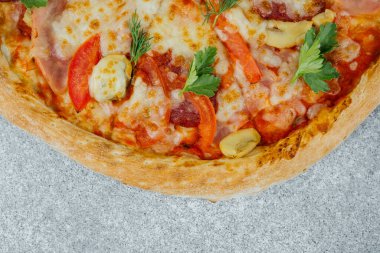 Taze bir pizza, erimiş peynir, canlı sebzeler ve mis kokulu bitkiler içerir..