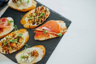 Üstü kabak ezmesi ve taze otlarla kaplı ustaca hazırlanmış ekmek dilimleri..