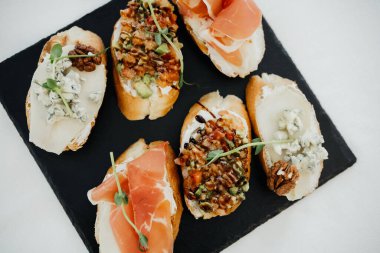 Tahtada eşsiz malzemelerle dolu canlı bir gurme bruschetta dizisi..