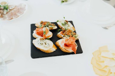 Lezzetli bruschetta üzerine taze malzemeler. Masada güzelce yerleştirilmiş..